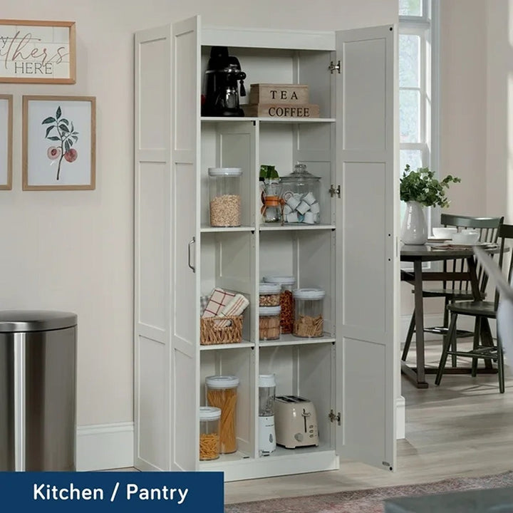 White kitchen pantry with shelves stocked with food items, located in a home setting.