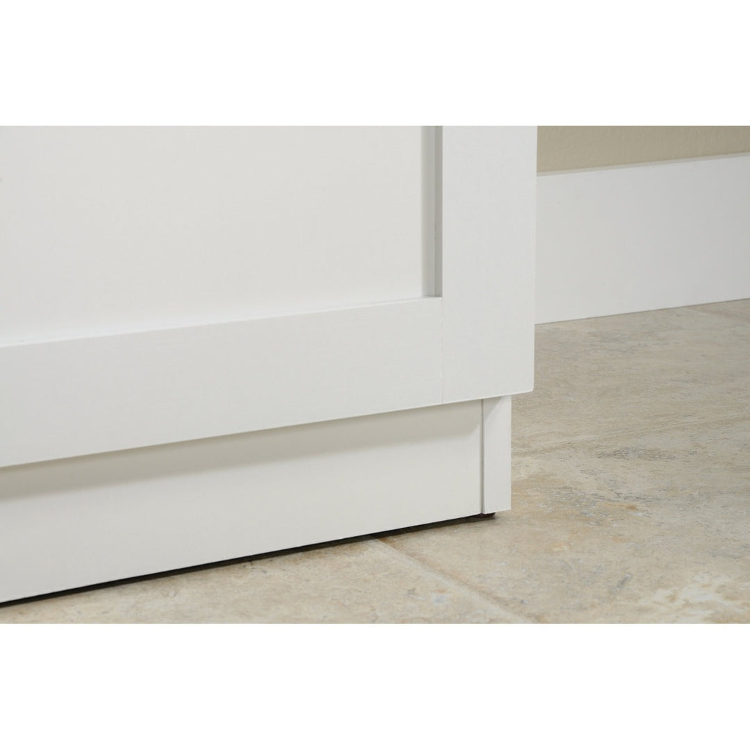 Close-up of a white cabinet base on a light wood floor