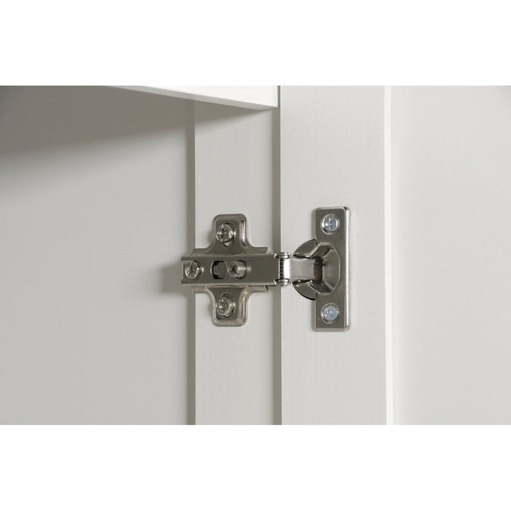 Close-up of a cabinet hinge on a white door