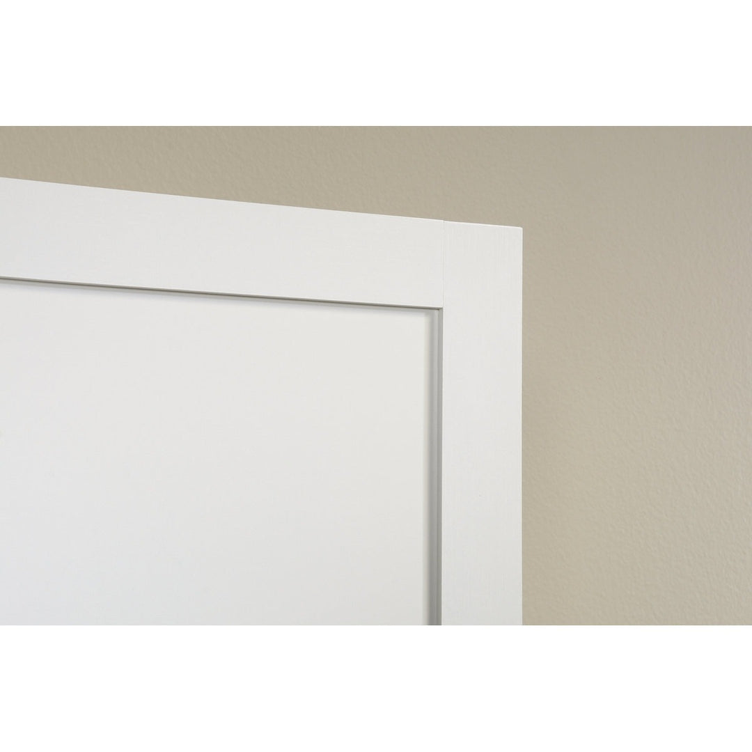 Close-up of a white door frame against a beige wall