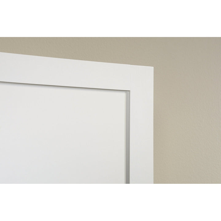 Close-up of a white door frame against a beige wall