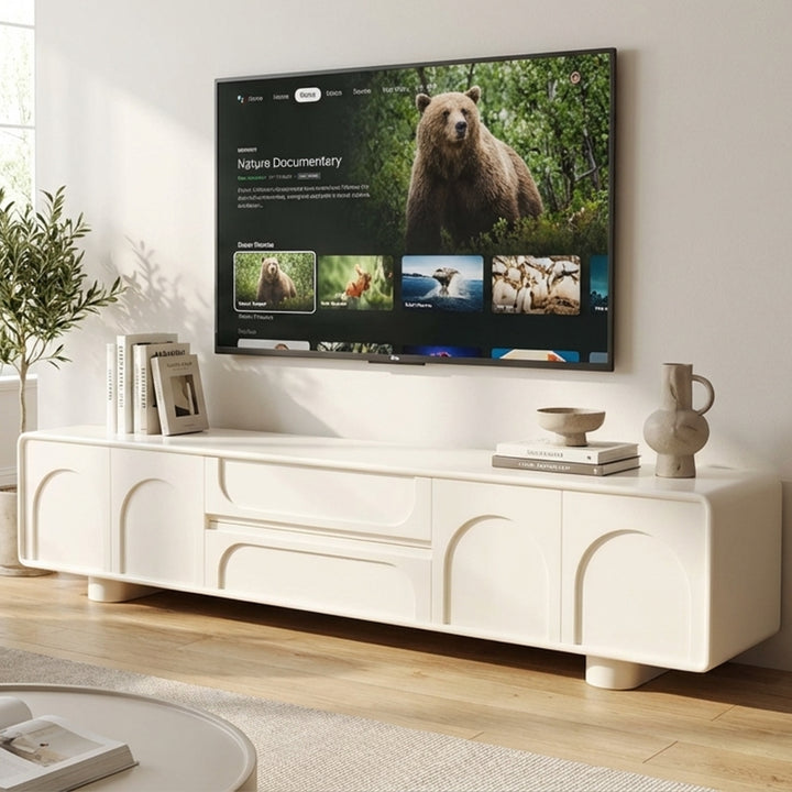 Modern living room with a white entertainment console and a TV displaying a nature documentary.