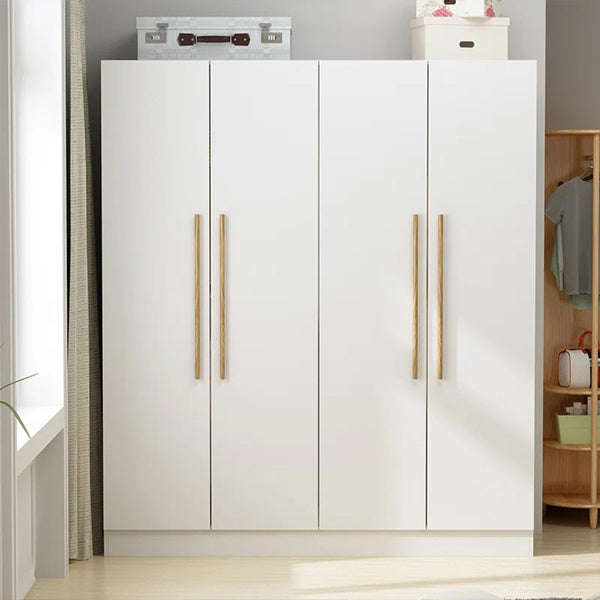 A white wooden wardrobe with four doors, featuring brown handles and a hanging rod, placed in a room with various children's toys and clothing.
