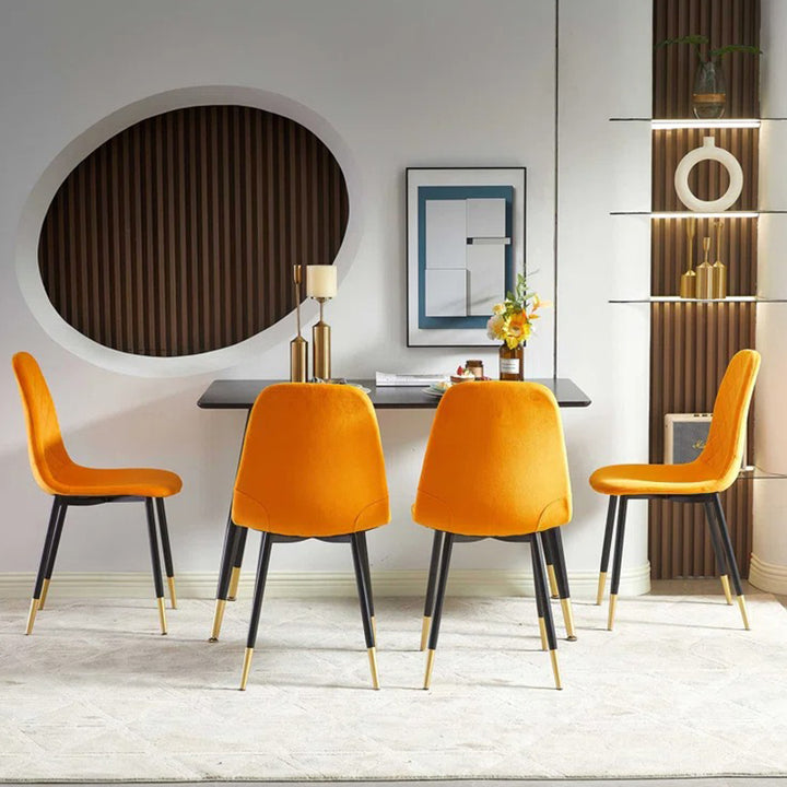Modern black dining table and 4 orange dining chair featuring black legs with gold accent