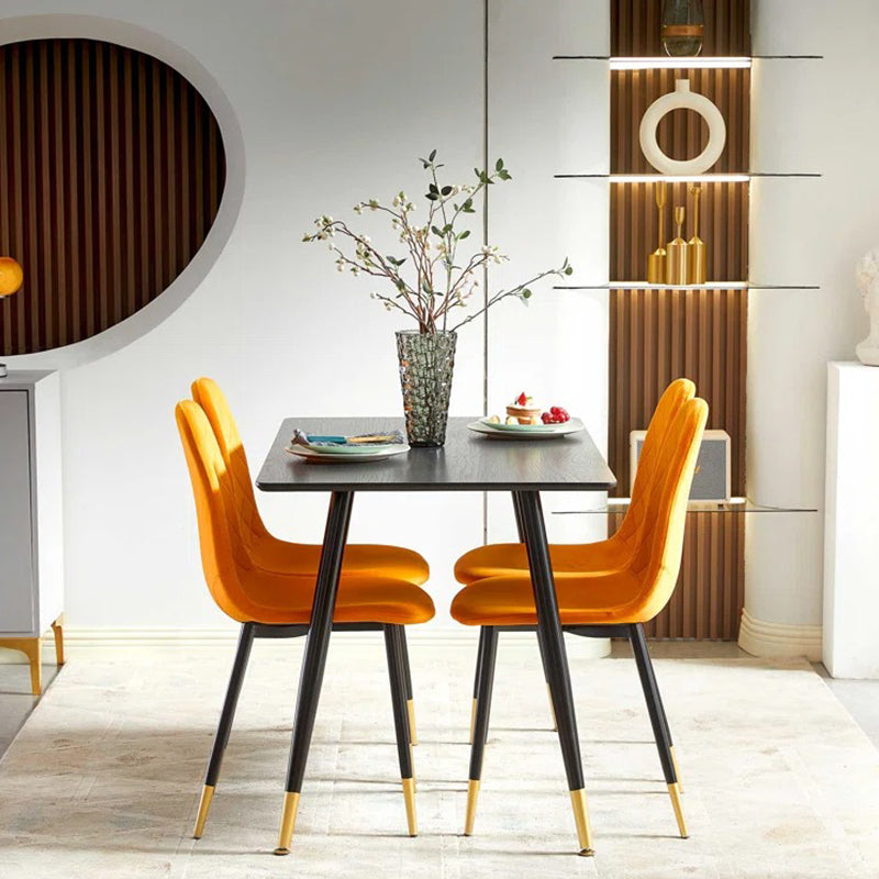 Stylish black dining table with orange dining chair featuring black legs with gold accent coating