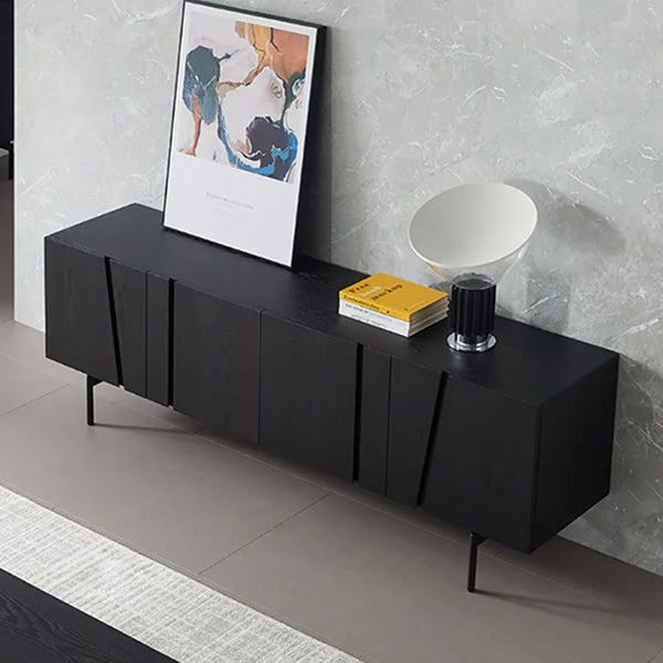 A large black sideboard with four doors and shelves, featuring a contemporary design, with decorative items and a framed abstract picture on top.
