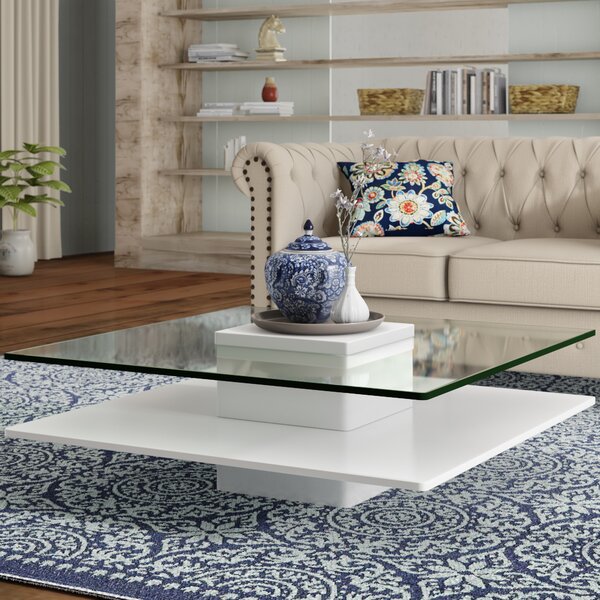 Sisvo white coffee table with square toughened glass top and gloss PU-painted base, styled in a modern living room.
