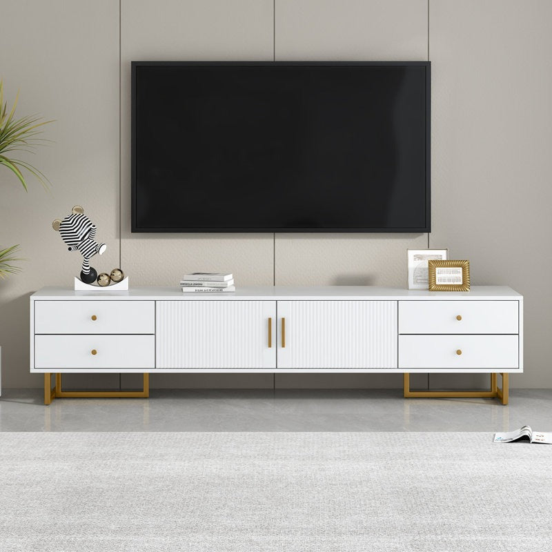 A large white TV stand with a wave-groove pattern and metal frame, featuring multiple storage drawers and a cabinet, with a flat-screen TV on top and decorative items on the stand.