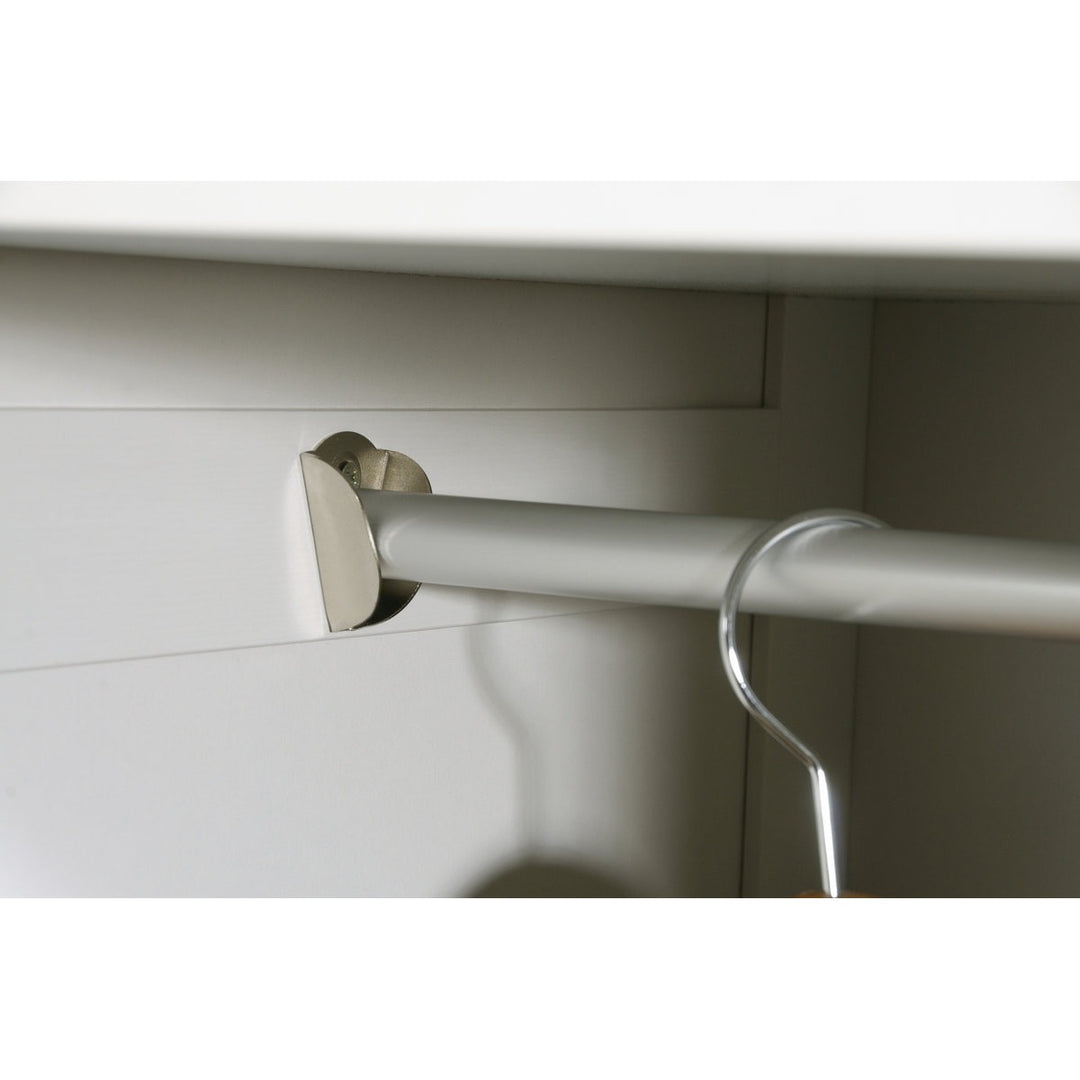 Metal curtain rod with bracket attached to a white cabinet