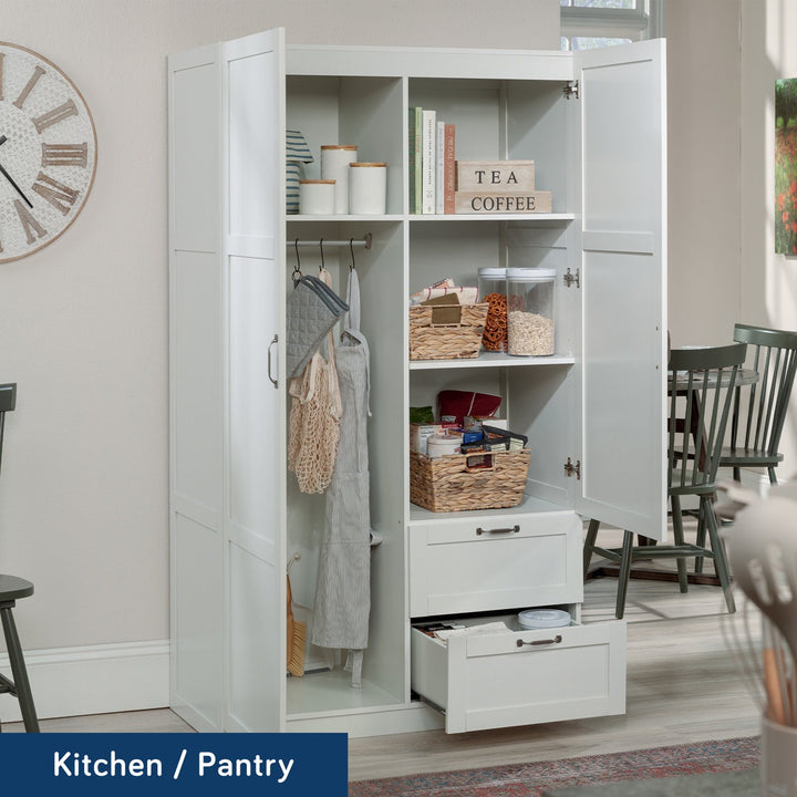White kitchen pantry with open doors displaying various items in a home setting.