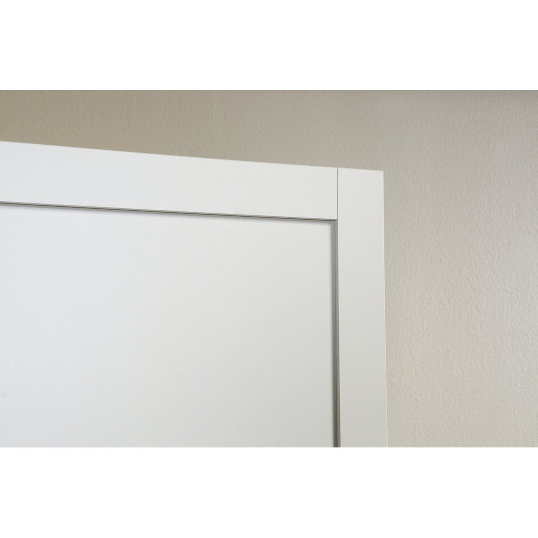Close-up of a white door frame against a beige wall