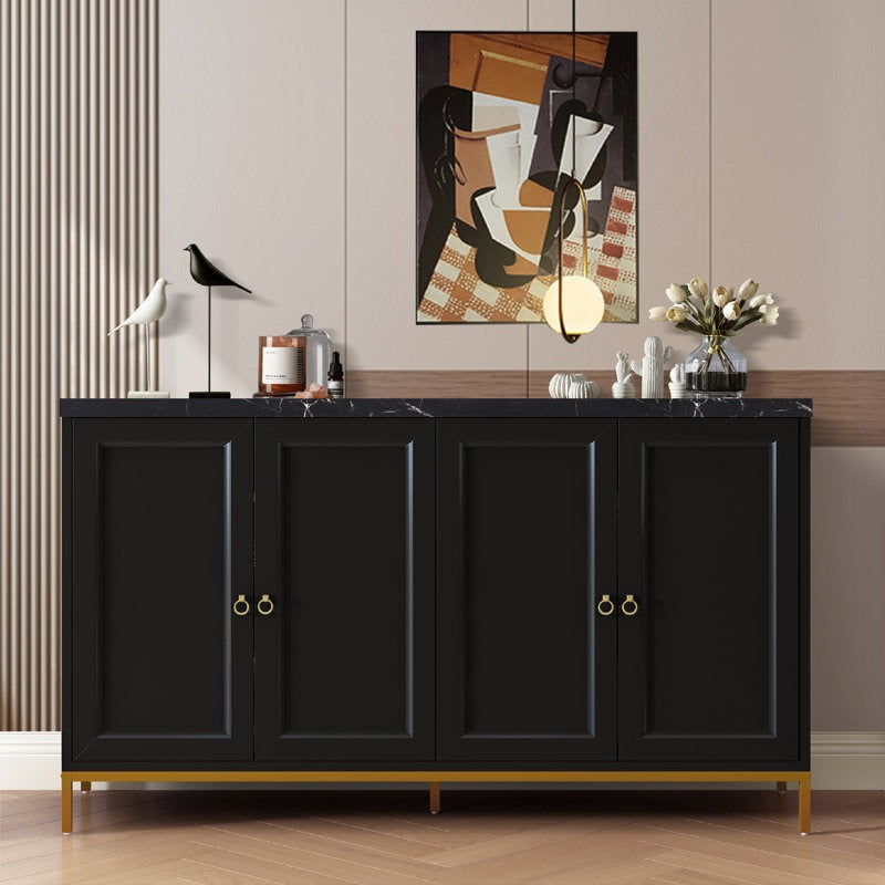 A large black Fanto sideboard with gold metal base and gold-tone handles, featuring a marble-effect top, situated in a room with a decorative wall art, a white bird sculpture, and some books.