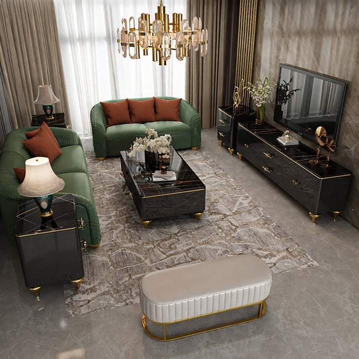 Stylish black coffee table with marble top and gold-colored legs placed in the center of the living room with a green sofa and black TV unit.