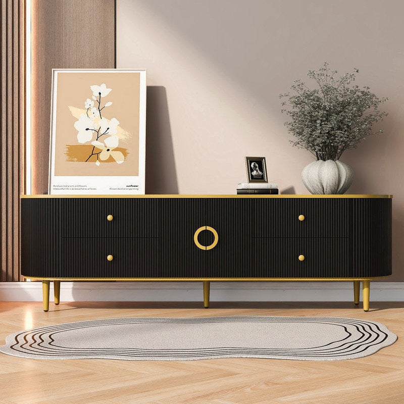 A modern black TV stand with golden strip detailing and golden legs, featuring four drawers and two openable shutters, placed in a room with a framed picture, a plant, and other decorative items on top.