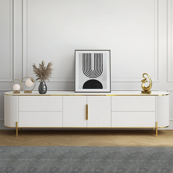 A white, half-round Edge TV stand with fluted corners, featuring a high-gloss PU-painted MDF finish, marble top, golden legs, and decorative strips. It is displayed in a living room setting with decorative items on top and a framed art piece above.