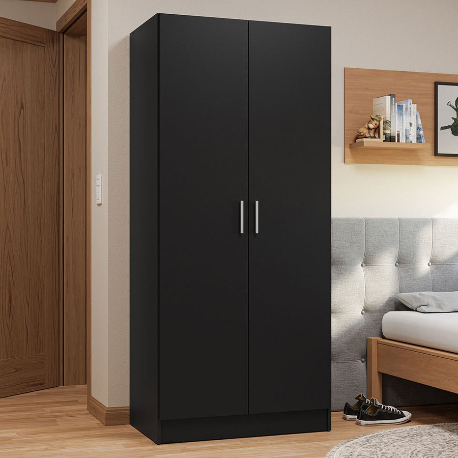 Black 2-door wardrobe design in a bedroom setting with a bed and wooden shelf in the background.