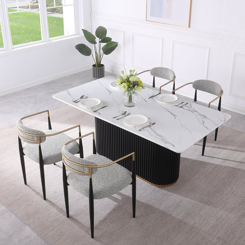 Modern 4-seater dining table set with a marble top and golden strip detail on the base, paired with four chairs upholstered in a golden, black, and grey pattern.