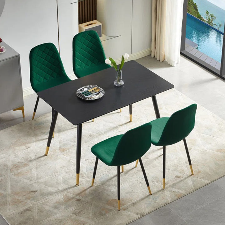 Black dining table with 4 green ergonomic chairs for compact space