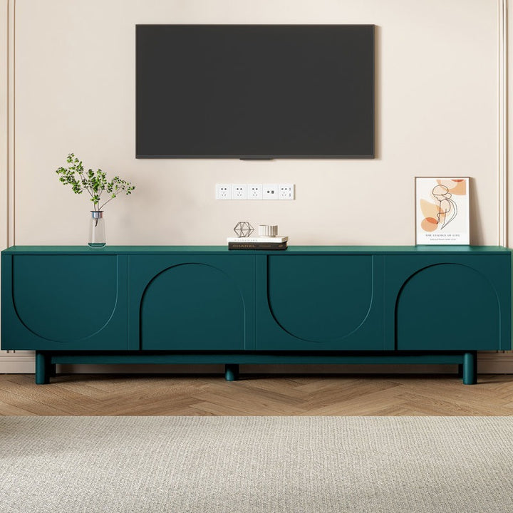 A large green Halo TV stand with arched doors and sleek legs, featuring a flat-screen TV on top, set against a room with minimalist decor.
