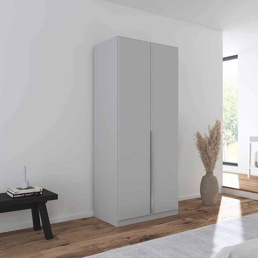 A grey 2-door wardrobe in gloss with integrated handles, positioned in a room with minimalist decor. 