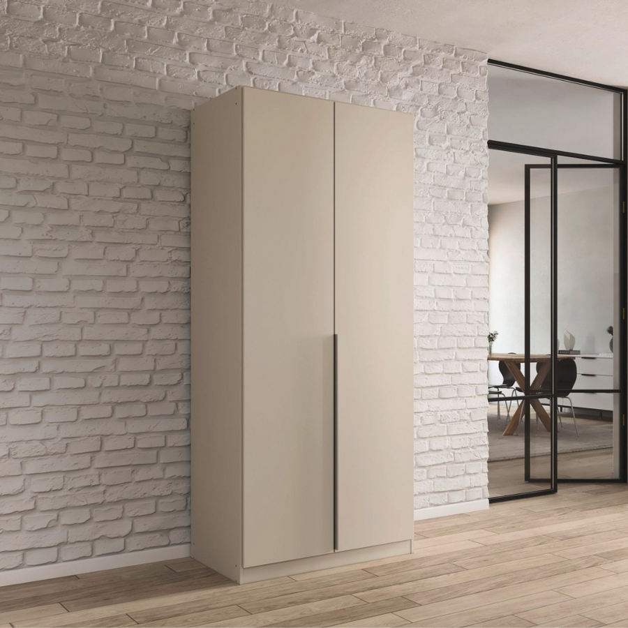 A beige 2-door wardrobe with a modern design, featuring a smooth finish and integrated handles, placed against a white brick wall background.