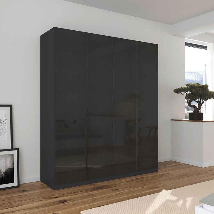 A glossy black 4-door wardrobe with handle-less doors, situated in a modern room setting with a minimalist design.