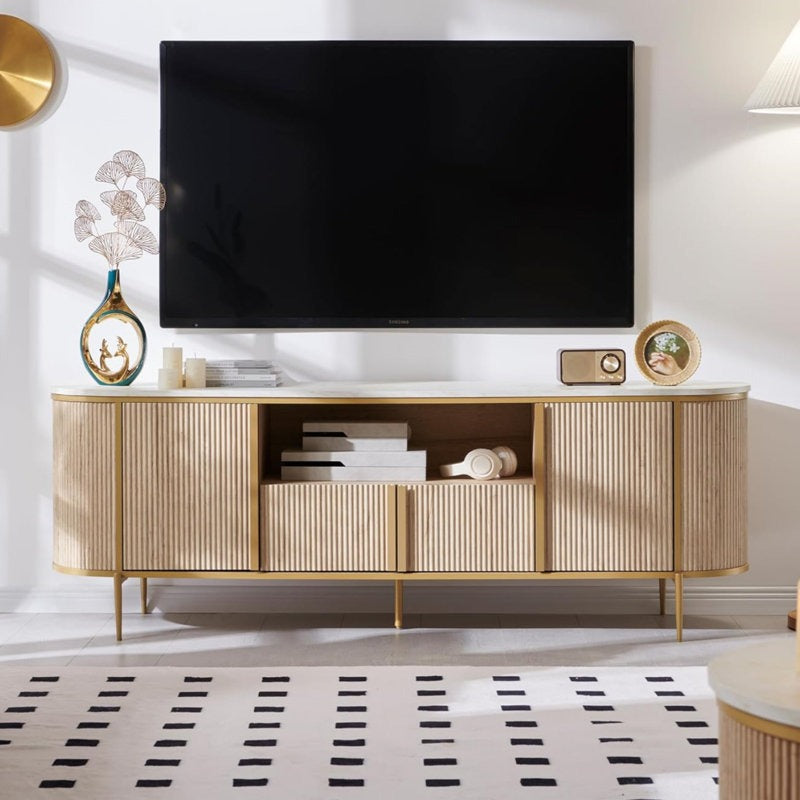 Modern beige and brown TV stand with a curved design, featuring multiple storage units and a flat-screen TV on top, placed in a room with decorative items and a patterned rug.