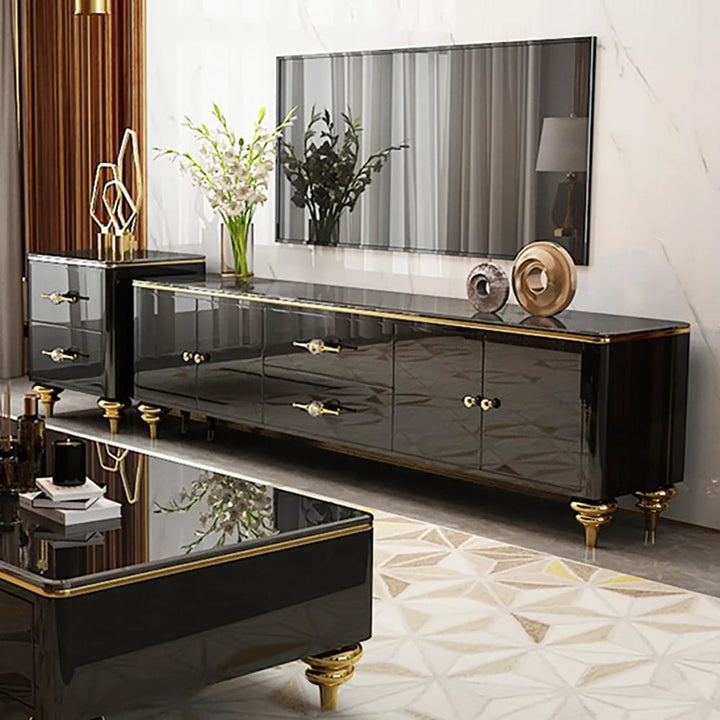 A premium black TV stand with a faux marble top, gold-finish handles and legs, storage compartments, and a flat-screen TV on top.