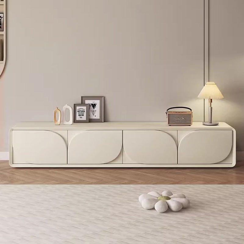 A sleek white Lotus TV unit with a high-gloss finish, featuring a spacious countertop and four push-to-open drawers, set in a modern living room interior.