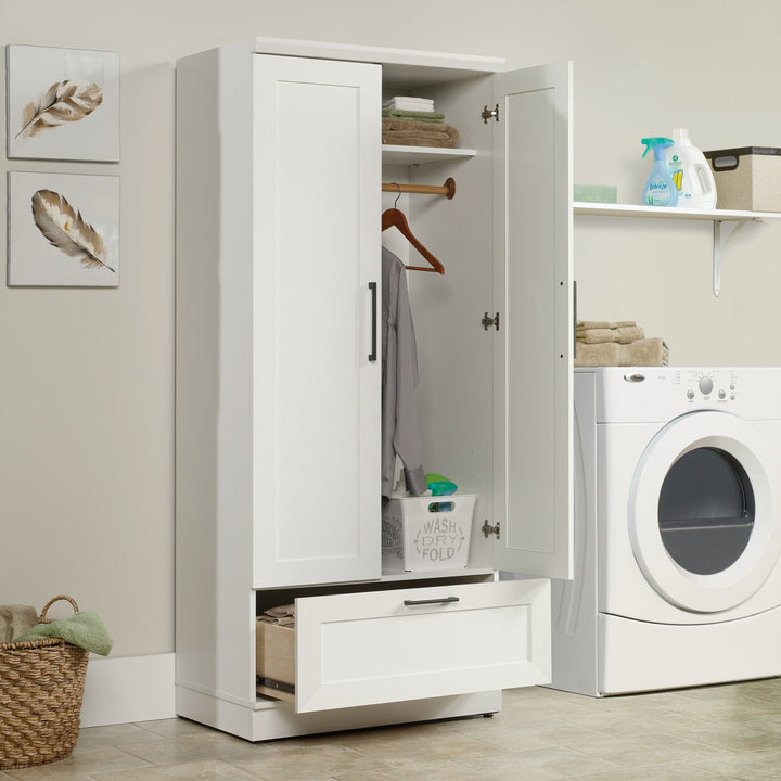 designer white 2-door wardrobe with open doors in a laundry room with a washing machine and shelves.