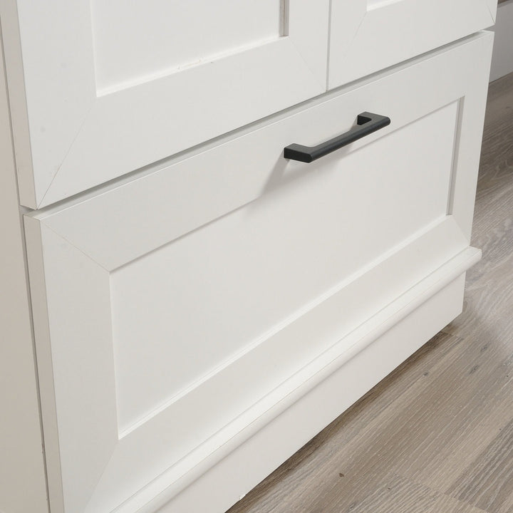 White cabinet with a black handle on a wooden floor