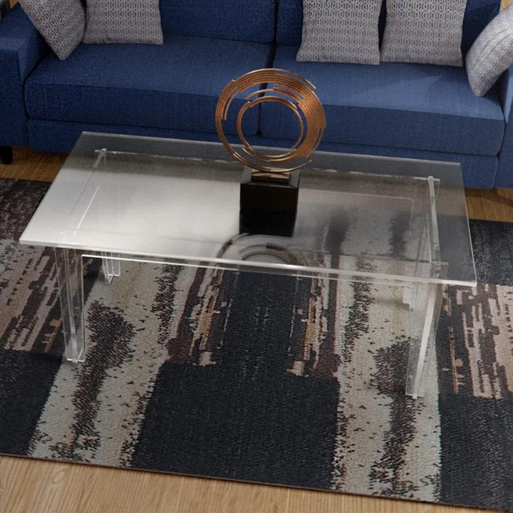 Modern clear coffee table with decorative item on top 