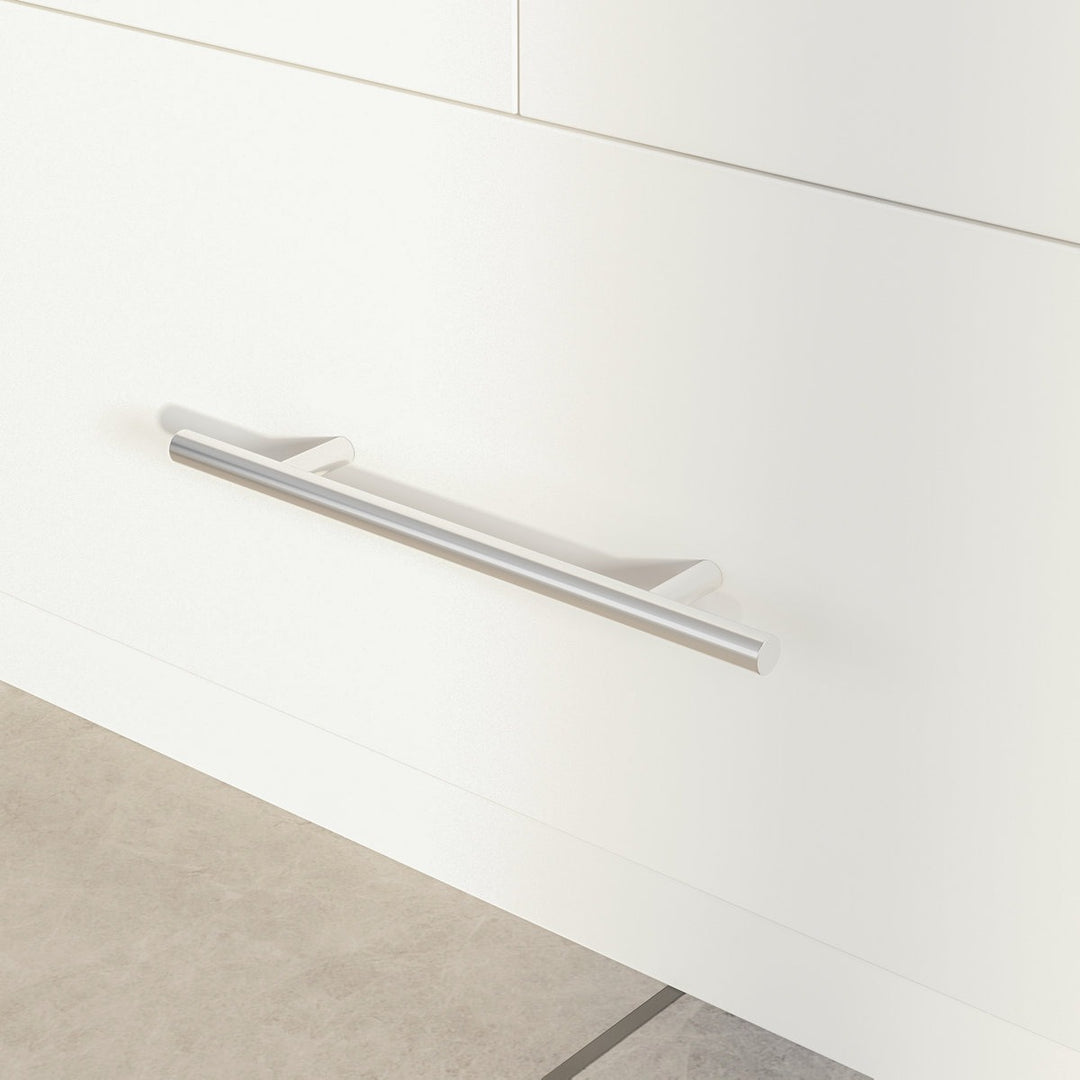 Close-up of a white cabinet with a silver handle on a light wood floor.