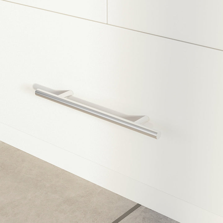 Close-up of a white cabinet with a silver handle on a light wood floor.