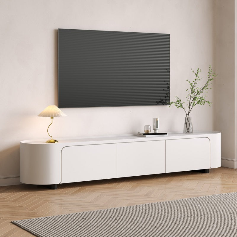 A modern white Robo TV stand with curved edges, featuring ample storage with drawers and open shelves, positioned in a room with a mounted television above it.