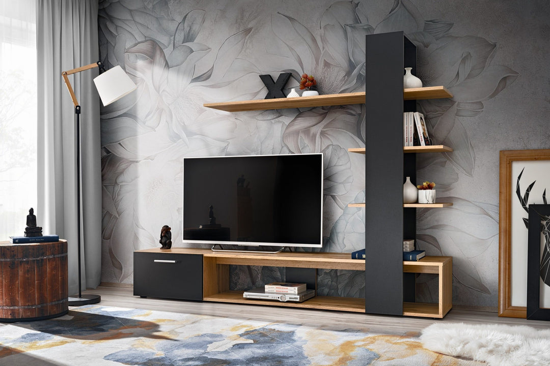 A premium TV unit set with natural wood and black finish, featuring an L-shaped asymmetrical design with open and closed storage and integrated vertical shelving. Placed in a room with decorative wallpaper.
