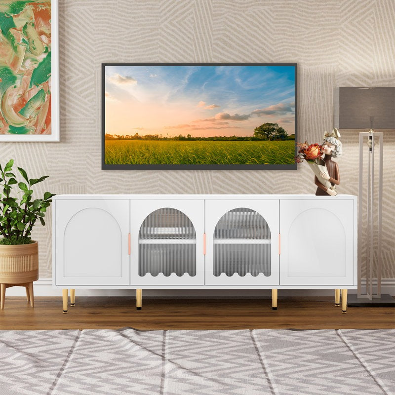 Modern white TV stand with dynamic wavy lines and ripple glass cabinet doors, featuring golden handles and legs, displayed in a room setting with a flat-screen TV on top.
