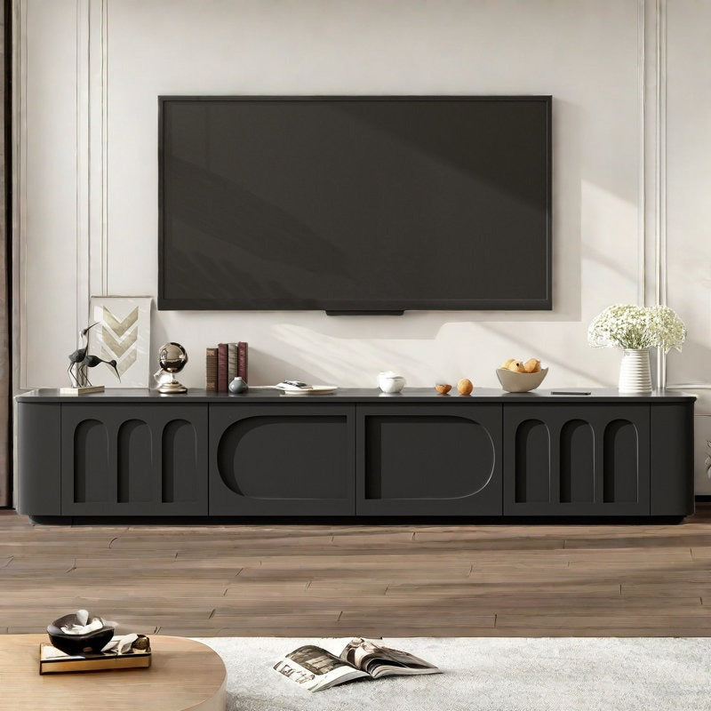A large black TV stand with arched doors and a sleek silhouette, featuring a flat-screen TV on top and a few decorative items.