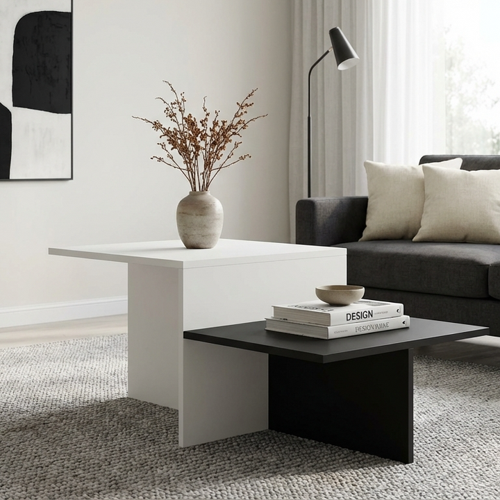 Modern living room with a black and white center table with 2-tier storage, a grey sofa, and an abstract painting.