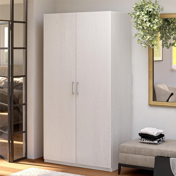 White 2-door wardrobe in a bedroom setting with a mirror and plant