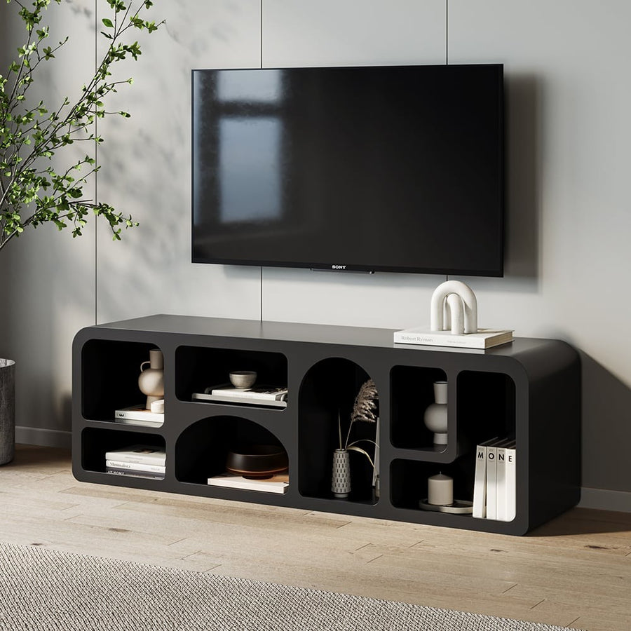Modern black TV shelves with multiple shelving units, upon which a flat-screen TV, decorative items, and books are placed, are set against a minimalist interior background.