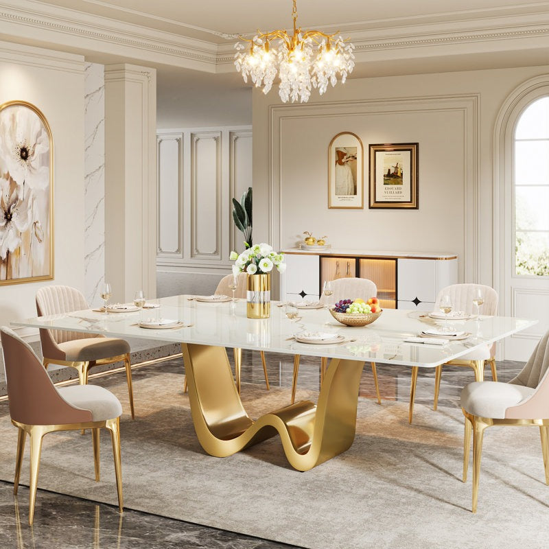 Elegant dining room with a W-shaped marble table and gold chairs.