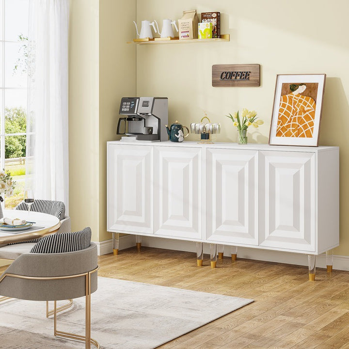A large white Bunny Sideboard with gold and acrylic legs, featuring an elegant 3D geometric pattern design, placed in a room with a coffee area and a framed picture on top.