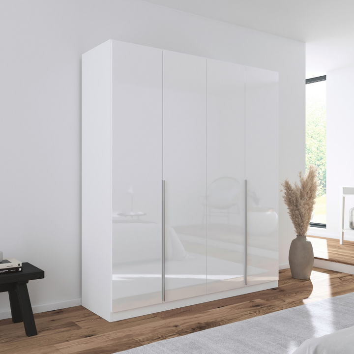 A white gloss 4-door wardrobe with handle-less doors, situated in a bright room.