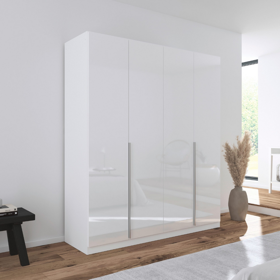 A white gloss 4-door wardrobe with handle-less doors, situated in a bright room.