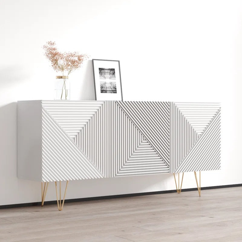 A modern white sideboard with a geometric pattern, featuring golden legs, a mix of drawers and open shelves, and a framed artwork on top.