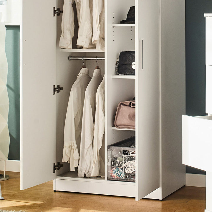 Premium white wardrobe with clothes and bags inside on a wooden floor.