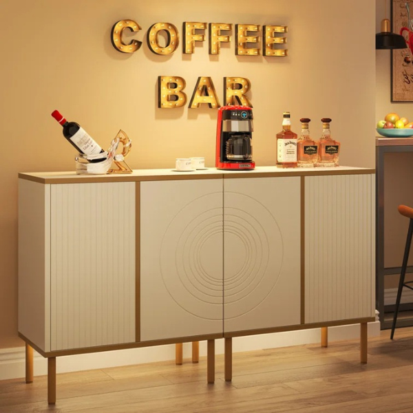 A white sideboard with gold legs featuring four doors and a coffee bar sign above it, placed in a room with various decor.